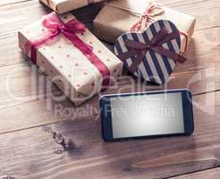 Smart phone near gift boxes. Clipping path included.