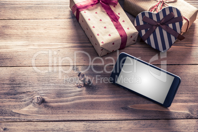 Smart phone near gift boxes. Clipping path included.