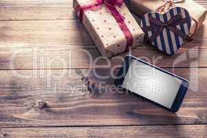 Smart phone near gift boxes. Clipping path included.