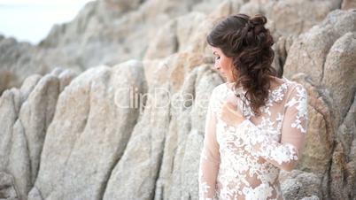 Young woman is beside the rock.