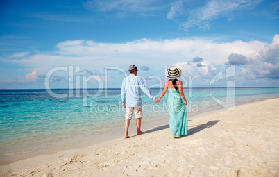 Vacation Couple walking on tropical beach Maldives.