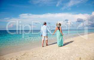 Vacation Couple walking on tropical beach Maldives.