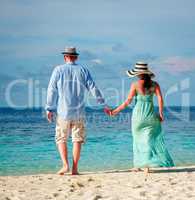 Vacation Couple walking on tropical beach Maldives.