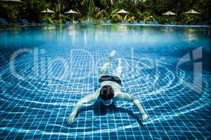 Man floats underwater in pool