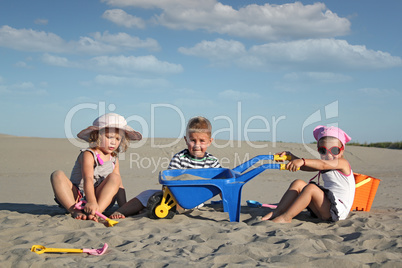 three children playing in sand