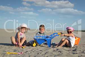 three children playing in sand