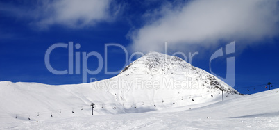 Panoramic view on ski slope at sun wind day