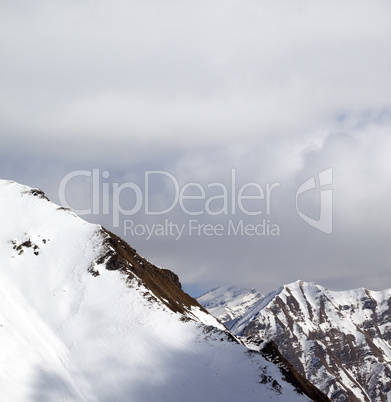 Snowy slope and sky with clouds at sun day