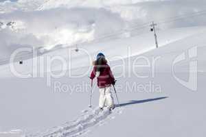 Girl on skis in off-piste slope with new fallen snow at nice day