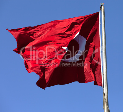 Turkish flag on flagpole waving in wind