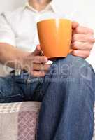 Man on a sofa with a cup of coffee