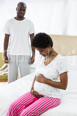 Pregnant woman sitting with hand on stomach