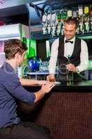 Bartender serving whiskey to man