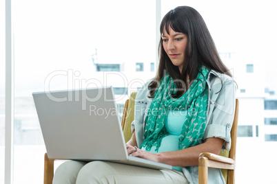 Pregnant woman using laptop