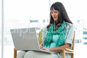 Pregnant woman using laptop