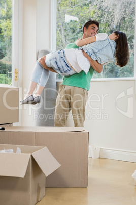 Young man lifting woman in his arms