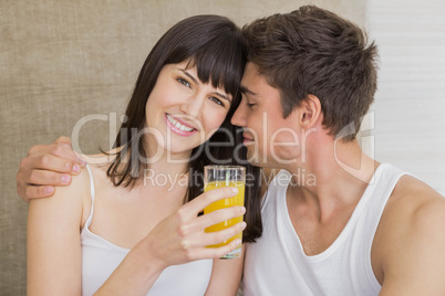 Woman drinking juice while man embracing