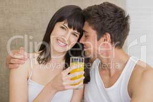 Woman drinking juice while man embracing