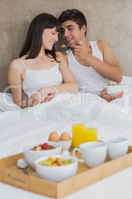 Man feeding breakfast cereals to woman