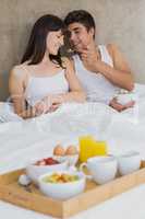 Man feeding breakfast cereals to woman