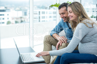 Couple using laptop in living room