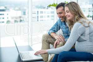 Couple using laptop in living room