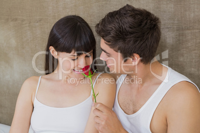 Man offering a red rose to woman