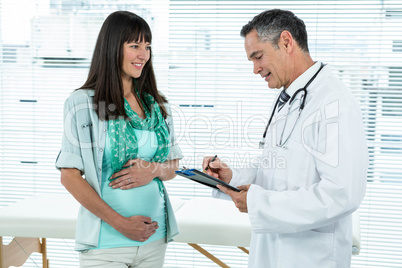 Doctor interacting with a pregnant woman at clinic