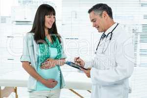 Doctor interacting with a pregnant woman at clinic