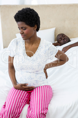 Pregnant woman sitting on bed