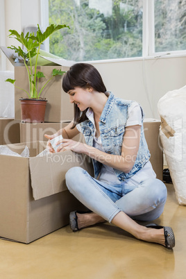 Young woman unpacking carton boxes