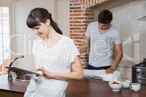 Woman using tablet in kitchen