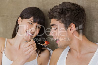 Woman feeding breakfast cereals to man