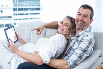 Expecting couple sitting on sofa
