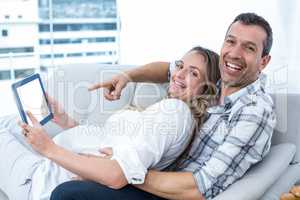 Expecting couple sitting on sofa