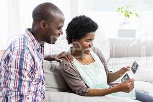 Pregnant couple looking at ultrasound scan