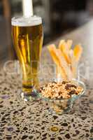 view of aperitif snacks on counter and pint of beer