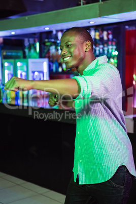 Happy man dancing in front of bar counter