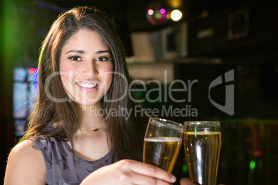 Portrait of beautiful woman toasting her beer glass