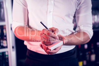 Waiter writing down an order