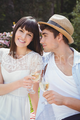 Young couple having glass of wine in garden