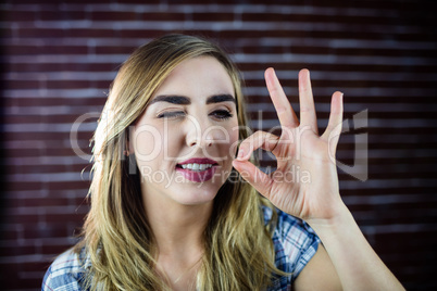 Pretty blonde woman making signs with her fingers