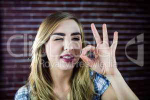 Pretty blonde woman making signs with her fingers