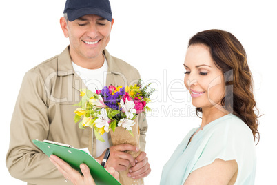 Female customer signing on paper with delivery man