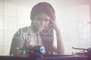 Pretty female DJ playing music