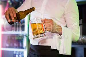 Bartender pouring beer in a pint