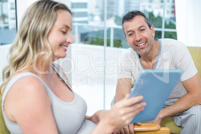 Expecting couple sitting on chair