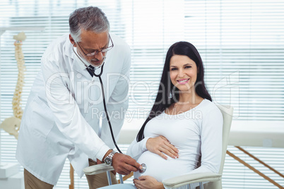 Doctor examining pregnant woman with a stethoscope