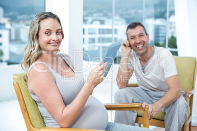 Expecting couple sitting on chair