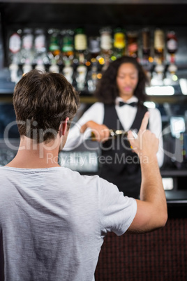 Man ordering a drink at bar counter